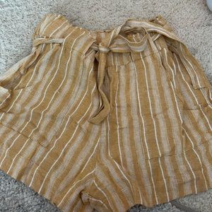 Yellow and white paper bag shorts with pockets.